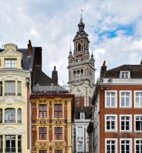 un groupe de bâtiments avec une tour d'horloge dans l'établissement JOST Auberge de Jeunesse Lille Centre, à Lille