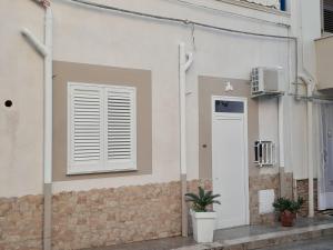 ein weißes Gebäude mit einem Fenster und einer Tür in der Unterkunft Casa Ciccio in Terrasini