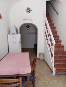 ein Esszimmer mit einem Tisch und einer Treppe in der Unterkunft Casa Ciccio in Terrasini