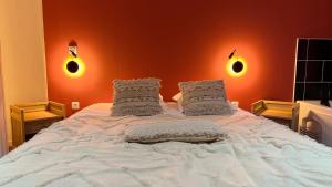 a bedroom with a large bed with orange walls at Balnéo Blanche Porte in Tourcoing