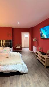 a bedroom with a large bed and a flat screen tv at Balnéo Blanche Porte in Tourcoing