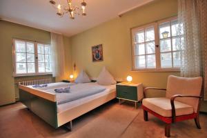 1 dormitorio con 1 cama, 1 silla y ventanas en Ferienwohnung in Garmisch-Partenkirchen mit Terrasse - b60502, en Garmisch-Partenkirchen