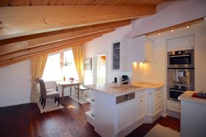eine Küche mit weißen Schränken und einem Tisch mit einem Esszimmer in der Unterkunft Tolle Wohnung in Breitenau mit Kleinem Garten in Garmisch-Partenkirchen