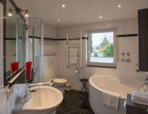 een badkamer met een bad, een toilet en een wastafel bij Schöne Wohnung in Garmisch-Partenkirchen und Bergblick in Garmisch-Partenkirchen