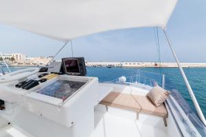 um barco branco na água com uma mesa sobre ele em "ULTIMA" una barca per sognare em Bari