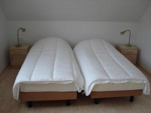two beds with white blankets on them in a room at Ferienhaus für 8 Personen ca 200 qm in Slupecna, Böhmen Moldau in Lipno nad Vltavou