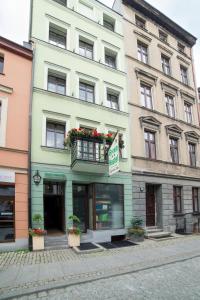 a large building with a balcony on a street at Green Hostel in Toruń