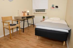 a bedroom with a bed and a desk and a chair at Britz Hostel in Kristinehamn