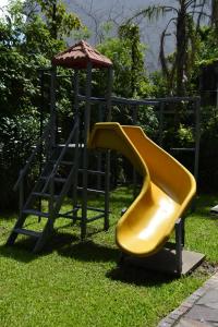 a yellow slide on a playground with an umbrella at Pampa Plaza Hotel in Buenos Aires