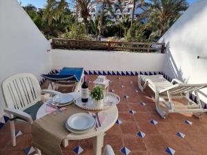 um pátio com uma mesa e cadeiras numa varanda em Schöne Wohnung in Playa De La Américas mit Gepflegtem Garten em Playa de las Americas