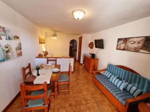 uma sala de estar com um sofá e uma mesa de jantar em Schöne Wohnung in Playa De La Américas mit Gepflegtem Garten em Playa de las Americas