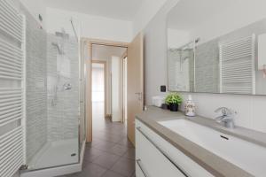 a white bathroom with a shower and a sink at [Niguarda] - Ampio e Moderno Trilocale in Milan +16 photos