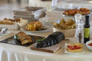 una mesa con un plato de comida en una mesa en Masseria Corda Di Lana Hotel & Resort, en Torre Lapillo