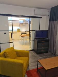 a living room with a yellow couch and a tv at Runaway Hill in Bežanija
