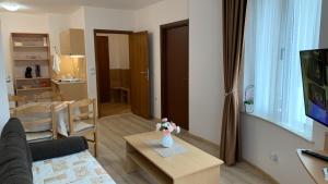 een woonkamer met een bank en een tafel in een kamer bij Апартамент Касъл in Pamporovo