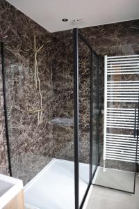 ein Bad mit einer Dusche und schwarzen Marmorwänden in der Unterkunft Knus appartement Tilburg in Tilburg