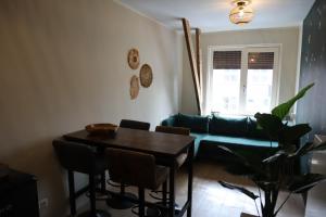 ein Wohnzimmer mit einem Tisch und einem grünen Sofa in der Unterkunft Knus appartement Tilburg in Tilburg