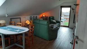 ein Wohnzimmer mit einem Tisch und einem grünen Sofa in der Unterkunft Gemüsekombüse in Ramstedt