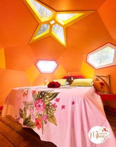 Bungalow Ti Koko في لو جوسيير: غرفة نوم مع سرير مع طاولة وردية