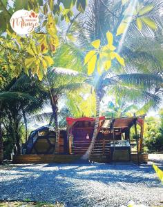 una cabina del resort con palme di fronte ad essa di Bungalow Ti Koko a Le Gosier