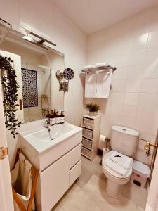 a white bathroom with a toilet and a sink at Apartamento Empul Costa Sancti Petri in Chiclana de la Frontera