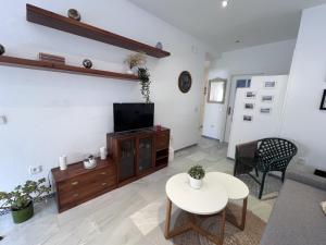 sala de estar con TV y mesa en Apartamento Empul Costa Sancti Petri en Chiclana de la Frontera