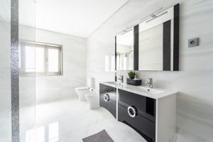 uma casa de banho branca com um lavatório e um espelho em Casa Eido Doce by House and People em Barcelos