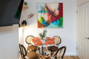 a dining room table with chairs and a painting on the wall at Charming 1-Bed Apartment in London in London