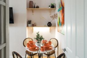 a dining room table with chairs and orange dishes on it at Charming 1-Bed Apartment in London in London