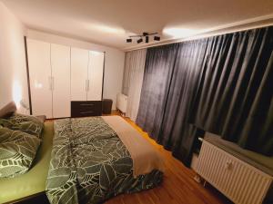Schlafzimmer mit einem Bett und einem Fenster mit Vorhängen in der Unterkunft Ridler in München