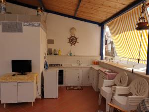 eine Küche mit einem Waschbecken und einem TV in der Unterkunft Casa Ciccio in Terrasini