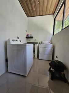 a kitchen with a stove and a washing machine at CASA TRES RIOS EN OSA in Coronado