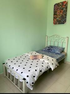 1 dormitorio con 1 cama con edredón blanco y negro en Kyuka Homestay Ladang Tanjung with Pool, en Kuala Terengganu