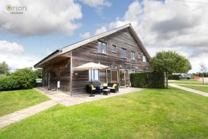 a wooden house with chairs and an umbrella at Waters Edge 04, Waterside Lodge P in South Cerney