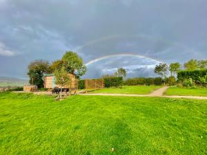 a rainbow in the sky over a green field at Romantic Escape with Hot Tub & Countryside Views in Leominster