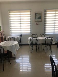 a dining room with tables and chairs and windows at San Sebastian in Concepción