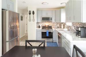 Una cocina con gabinetes blancos y una encimera negra. en Inviting 3BR Home Near Little Rock Attractions!, en North Little Rock