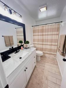 a bathroom with a sink and a toilet and a shower at Casa Malia -salt water oasis in Desert Hot Springs