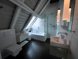 ein Badezimmer mit einem Waschbecken und einer Badewanne in der Unterkunft L'Eau Forte - maison d'hôtes in Saint-Blaise