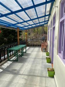 a patio with a green picnic table on a house at Farmvilla Homestay in Kalpa
