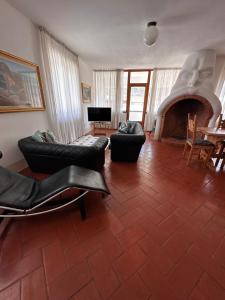 un soggiorno con 2 divani e un camino di Ampio Appartamento con vista “Casa Magro” a Tirano
