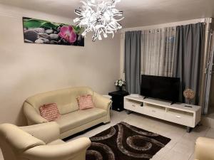 a living room with a couch and a flat screen tv at La maison est située en face de la gare in Bondy