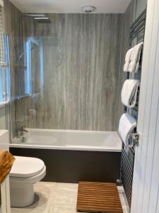 a bathroom with a tub and a toilet and a sink at Clashmore Wood in Dornoch