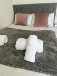 a pile of white rolled towels on a bed at Private room in London with balcony in Woolwich