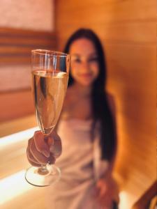 Babyhotel Karolínka, wellness في فرانوف ناد ديجي: امرأة تمسك كأس من الشمبانيا