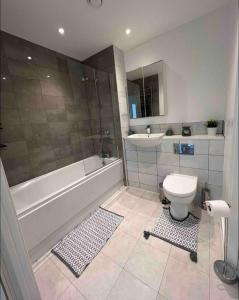 y baño con bañera, aseo y lavamanos. en Private room in London with balcony en Woolwich