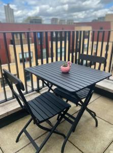 una mesa de picnic con un juguete de flamenco rosa en el balcón en Private room in London with balcony en Woolwich