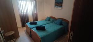 a bedroom with a green bed with blue pillows at 54 RW Ashley in Naxxar