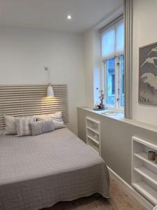 Habitación blanca con cama y ventana en City center apartment w/ large private balcony, en Aalborg