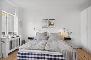 Un dormitorio blanco con una cama grande. en City center apartment w/ large private balcony, en Aalborg